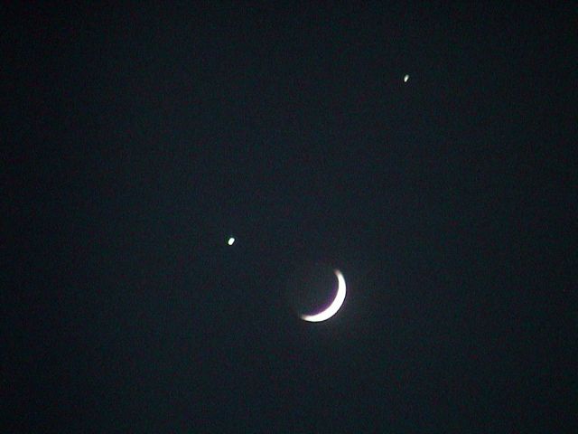 Die Mondsichel steht zwischen zwei ganz hell leuchtenendn Sternen.